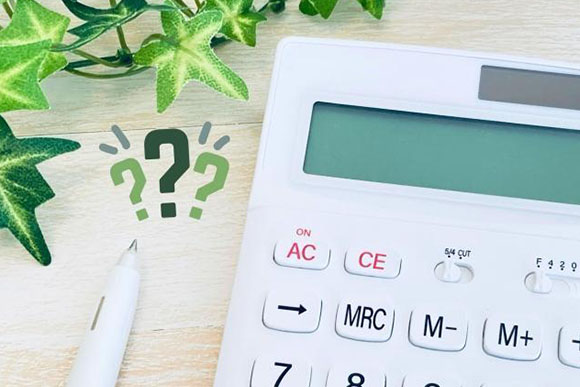 白い電卓とボールペン＋はてなマーク