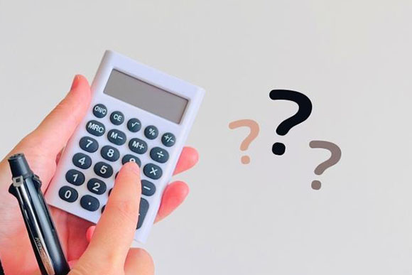 電卓を打つ手元とクエスチョンマーク