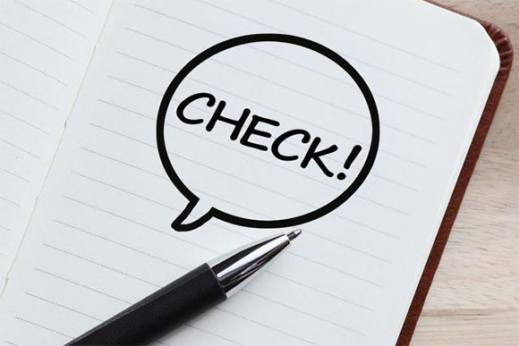 ノートに書かれたCHECKの文字とペン