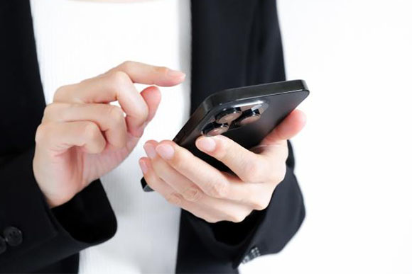 スマートフォンを使う女性の手元